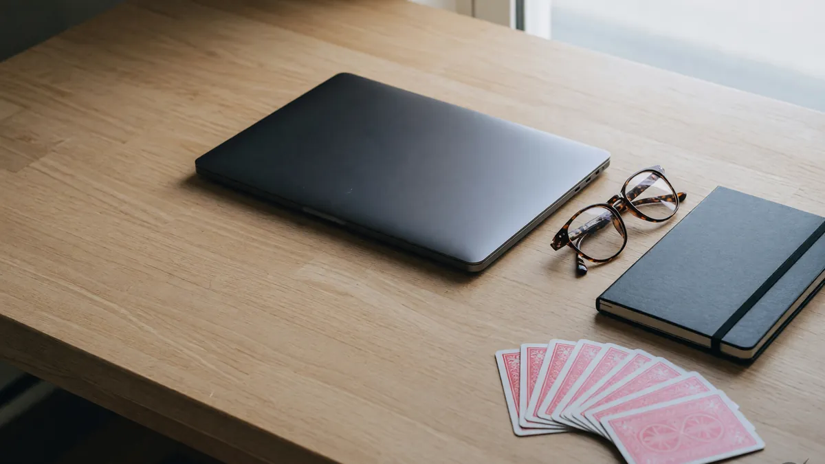 A usability desk with a dark laptop and a rummy fan